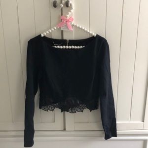Bebe black long sleeve top with beautiful floral appliqué at hemline. XS